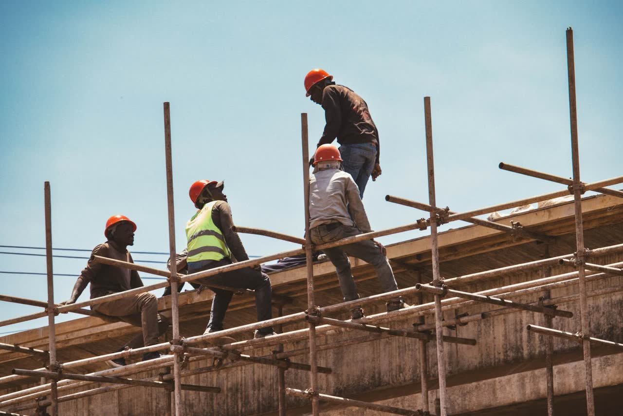 Construction crew working on scaffolding at height on a commercial building